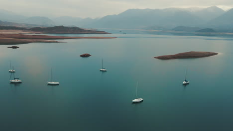 Lago-Sereno-Ubicado-Entre-Picos-Montañosos,-Donde-Los-Barcos-Navegan-Con-Gracia-En-Aguas-Tranquilas,-Ofreciendo-Un-Escape-Pacífico-Al-Abrazo-De-La-Naturaleza.