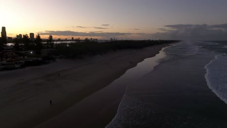 Surfers-Paradise,-Gold-Coast,-Queensland,-Australia,-drone,flying-low-alond-the-surf-beach-at-sunset