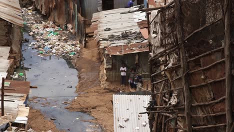 Children-playing-near-open-air-sewage-in-Kibera,-Nairobi