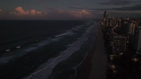Surfers-Paradise,-Gold-Coast,-Queensland,-Australia,-drone,-Lights-come-on-as-the-sunsets-at-this-famous-holiday-destination