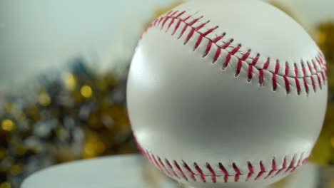 Cinematic-close-up-shot-of-a-white-base-ball,-red-stitches-baseball-on-a-shiny-stand,-Christmas-blurry-decorations-in-the-background,-professional-studio-lighting,-4K-video-pan-right