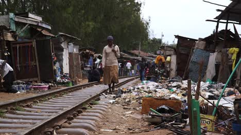 Männer-Und-Frauen,-Die-Entlang-Der-Eisenbahn-Im-Slum-Von-Kibera-Laufen
