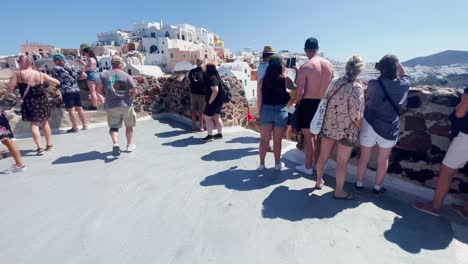 Oia-Santorini-Greece-Island-Travel-Tourist-Immersive-Walk,-Europe,-4K-|-Greek,-Aegean,-Sea,-Cliffside,-Ocean,-City,-Vacation,-Shopping,-White,-Marble,-Crowd,-Flowers,-Traveler,-People,-Panorama,-Edge