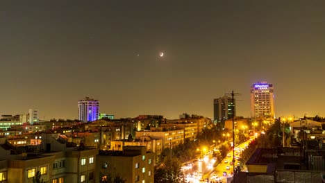 Sunset-Moonset-in-Iran-city-landscape-urban-lifestyle-in-modern-country-in-middle-east-asia-saudi-arabia-tourism-destination-golden-color-twilight-planet-astronomical-night-sky-time-lapse-car-driving