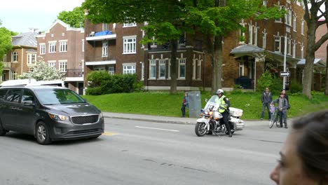 Police-pulls-out-side-road-in-cruiser-motorcycle-turns-light-on-in-Quebec-City,-Canada