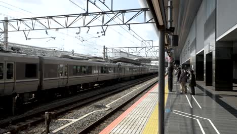 JR-Thunderbird-Express-Train-Arriving-At-Kyoto-Station-Platform-As-Local-Train-Is-Going-Past