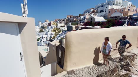 Oia-Santorini-Greece-Island-Travel-Tourist-Immersive-Walk,-Europe,-4K-|-Greek,-Aegean,-Sea,-Cliffside,-Ocean,-City,-Vacation,-Shopping,-White,-Marble,-Crowd,-Flowers,-Traveler,-People,-View,-Couple