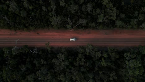 drone-top-shot-of-a-van-driving-through-australian-bush-on-a-red-dirt-road-in-western-australia
