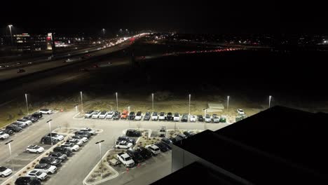 Jaguar-and-Land-Rover-luxury-car-dealership---pullback-aerial-reveal-at-nighttime