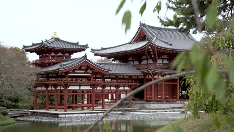 Background-Focus-Shot-Past-Leaves-And-Tree-Branches-View-Of-Phoenix-Hall-At-Byodo-In-Buddhist-Temple-In-Uji