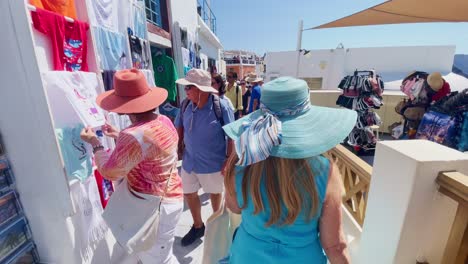 Oia-Santorini-Greece-Island-Travel-Tourist-Immersive-Walk,-Europe,-4K-|-Greek,-Aegean,-Sea,-Cliffside,-Ocean,-City,-Vacation,-Shopping,-White,-Marble,-Crowd,-Flowers,-Traveler,-People,-Hat,-Elderly