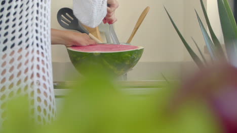 Eine-Frau-Schneidet-In-Der-Küche-Eine-Wassermelone-Mit-Einem-Großen-Messer