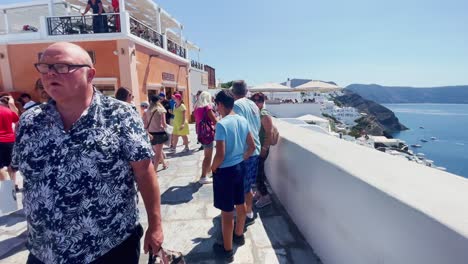 Oia-Santorini-Greece-Island-Travel-Tourist-Immersive-Walk,-Europe,-4K-|-Greek,-Aegean,-Sea,-Cliffside,-Ocean,-City,-Vacation,-Shopping,-White,-Marble,-Crowd,-Flowers,-Traveler,-People,-Church,-Busy