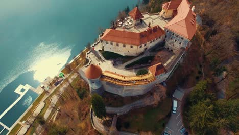 Drone-slow-left-rotating-flying-view-of-lake-Bled-sunlit-castle-on-cliff