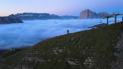 Photographer-on-the-mountain-above-clouds-shot-with-drone-in-the-Italian-Alps,-Dolomites