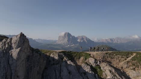 Hikers-walking-on-the-ridge-of-the-mountain-filmed-with-a-drone-at-Seceda,-Italian-alps,-Dolomites