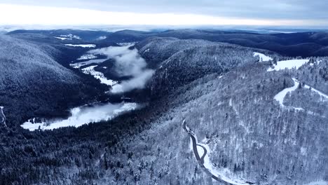 Aerial-slow-fly-view-of-the-snow-capped-valley-of-the-lakes-during-winter-in-Hautes-Vosges,-France