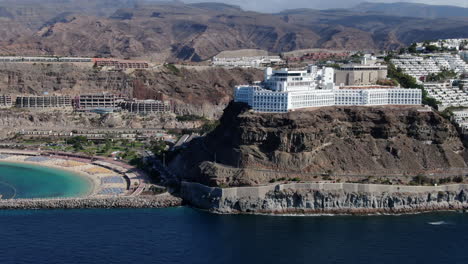 Luftaufnahme-über-Den-Strand-Von-Amadores-Und-Die-Resorts-In-Küstennähe-In-Der-Stadt-Mogan,-Gran-Canaria
