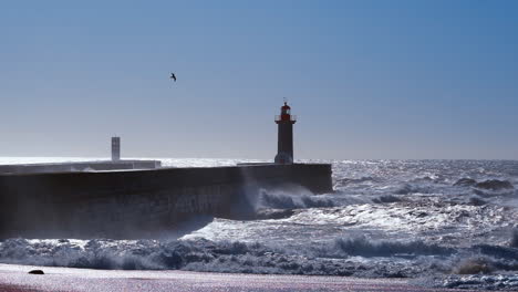 Цinematic-depiction-of-sizable-waves-crashing-in-proximity-to-the-Felgueiras-Lighthouse,-located-in-Porto,-Portugal,-serves-as-a-symbol-of-maritime-legacy-and-coastal-allure