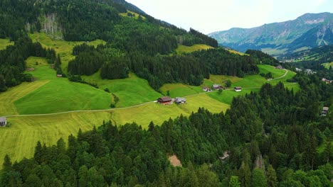 Flying-over-Sorenberg-village-in-the-Swiss-Alps-surrounded-by-mountains-and-pine-trees,-Europe