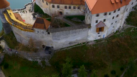 Drone-backwards-descending-moving-view-of-lake-Bled-island-and-castle-reveal