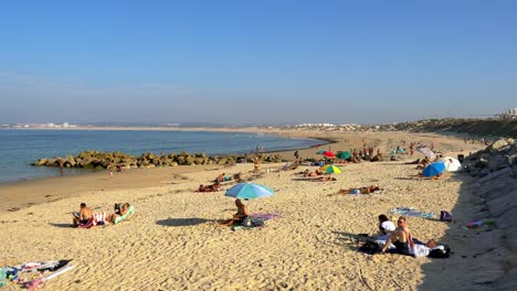 Portugal,-Peniche,-Praia-da-Gamboa-sandy-beach-in-autumn-with-sunbathing-people