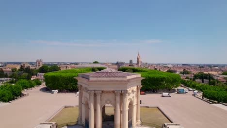 Gaypride-2023-aerial-shot-around-the-crowded-gardens-of-Peyrou,-flying-over-the-water-tower-in-Montpellier