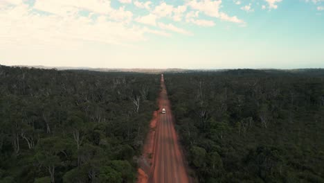 Drohnenaufnahme-Eines-Lieferwagens,-Der-Aus-Der-Ferne-In-Westaustralien-Auf-Einer-Roten,-Unbefestigten-Australischen-Straße-Fährt