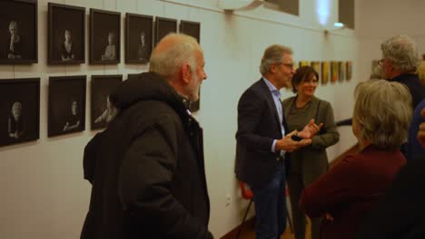 Older-grey-haired-man-with-beard-and-woman-communicating-talking-and-joking-at-art-fair