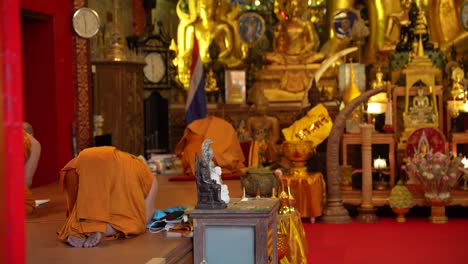 Buddhist-monks-bowing-inside-the-Wat-Phra-That-Doi-Suthep-temple-in-Chiang-Mai,-Thailand
