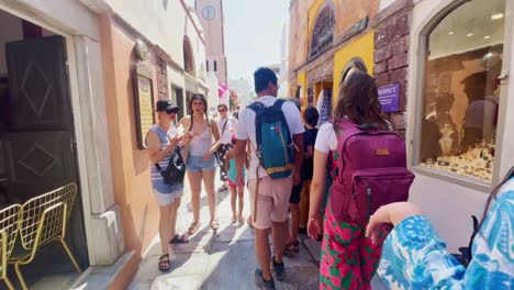 Oia-Santorini-Greece-Island-Travel-Tourist-Immersive-Walk,-Europe,-4K-|-Greek,-Aegean,-Sea,-Cliffside,-Ocean,-City,-Vacation,-Shopping,-White,-Marble,-Crowd,-Flowers,-Traveler,-People,-Dress,-Active