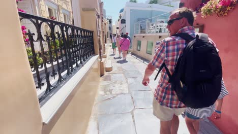 Oia-Santorini-Greece-Island-Travel-Tourist-Immersive-Walk,-Europe,-4K-|-Greek,-Aegean,-Sea,-Cliffside,-Ocean,-City,-Vacation,-Shopping,-White,-Marble,-Crowd,-Flowers,-Traveler,-People,-Man,-Child
