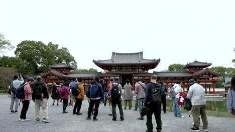 Grupo-De-Turistas-Tomando-Fotografías-Del-Phoenix-Hall-En-Byodo-in-Ubicado-En-Uji,-Japón.