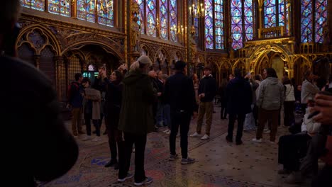 Large-group-of-tourists-admiring-the-interior-of-the-main-chapel-inside-the-Sainte-Chapelle-church-in-Paris,-France