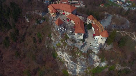 Drone-rotating-left-flying-view-of-lake-Bled-castle-on-cliff,-colourful-nature
