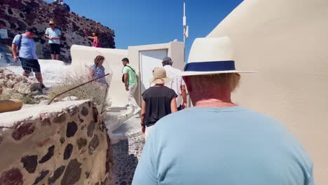 Oia-Santorini-Greece-Island-Travel-Tourist-Immersive-Walk,-Europe,-4K-|-Greek,-Aegean,-Sea,-Cliffside,-Ocean,-City,-Vacation,-Shopping,-White,-Marble,-Crowd,-Flowers,-Traveler,-People,-Elder,-Narrow