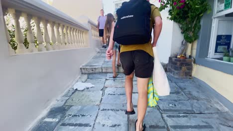 Oia-Santorini-Greece-Island-Travel-Tourist-Immersive-Walk,-Europe,-4K-|-Greek,-Aegean,-Sea,-Cliffside,-Ocean,-City,-Vacation,-Shopping,-White,-Marble,-Crowd,-Flowers,-Traveler,-People,-Elder,-Bags