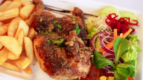 Delicious-fried-chicken-wings-and-french-fries-served-with-salad,-close-up-view