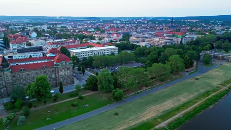 Panoramic-aerial-view-of-Dresden,-a-capital-city-in-Germany,-featuring-a-bridge,-river,-historic-buildings,-and-city-traffic,-all-along-tree-lined-streets