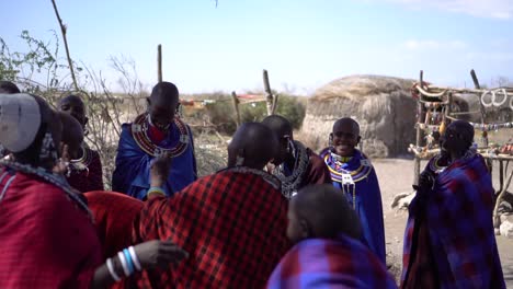 Zeitlupe-Von-Maasai-Stammweibchen-Mit-Rasierten-Köpfen,-Die-Im-Schatten-Eines-Baumes-Lächeln