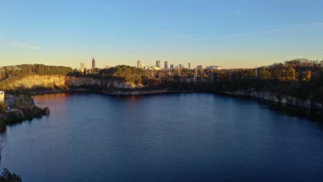 Panoramic-aerial-view-of-Westside-Reservoir-Park-overlooking-Atlanta-skyline-at-sunrise,-Georgia,-USA