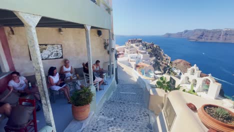 Oia-Santorini-Griechenland-Insel-Reise-Tourist-Immersiver-Spaziergang,-Europa,-4k-|-Griechisch,-Ägäis,-Meer,-Klippe,-Ozean,-Stadt,-Urlaub,-Einkaufen,-Weiß,-Marmor,-Menschenmenge,-Blumen,-Reisender,-Menschen,-Café,-Treppe