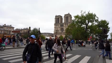 Establishing-in-the-crowded-streets-of-Paris-next-to-the-Notre-Dame-Cathedral-on-a-cloudy-day-on-the-zebra-crossings