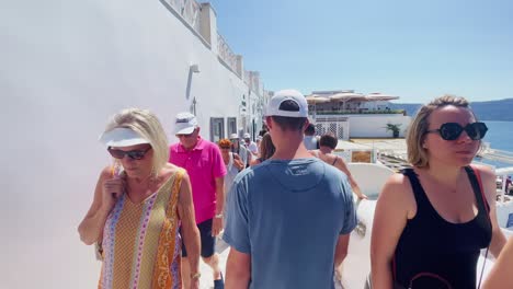 Oia-Santorini-Greece-Island-Travel-Tourist-Immersive-Walk,-Europe,-4K-|-Greek,-Aegean,-Sea,-Cliffside,-Ocean,-City,-Vacation,-Shopping,-White,-Marble,-Crowd,-Flowers,-Traveler,-People,-Path,-Overlook