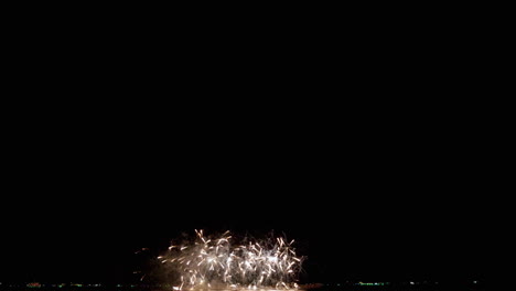 Big-diameter-of-white-explosions-followed-by-the-same-pattern-but-starts-with-orange-then-the-base-are-red-sparks,-Fireworks-Display