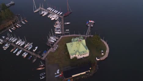 Luoto-and-Valkosaari-islands,-Aerial,-drone-shot,-panning-around-a-restaurant-and-buildings,-in-the-Helsinki-archipelago,-at-sunrise,-on-a-foggy-autumn-morning,-in-Helsingfors,-Uusimaa,-Finland