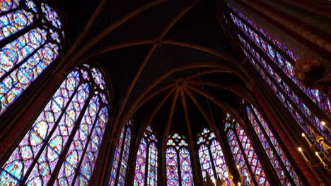 Tilt-down-in-the-Upper-Chapel-of-the-Sainte-Chapelle-in-Paris-France-with-tourists-photographing-its-purple-stained-glass-windows