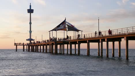 People-walking-on-Brighton-Beach-jetty-in-the-evening,-Adelaide,-South-Australia