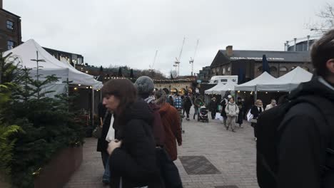 POV-Walking-Past-Local-Market-Stalls-At-Coal-Drops-Yard-In-Kings-Cross-During-Christmas-Festive-Season-On-Overcast-Day