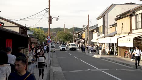 October-Sunny-Afternoon-View-Along-Prefectural-Road-29-in-Arashiyama-With-People-Walking-Past,-Kyoto,-Japan